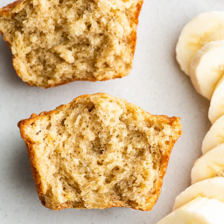 overhead view of a banana muffin cut in half with sliced bananas next to it