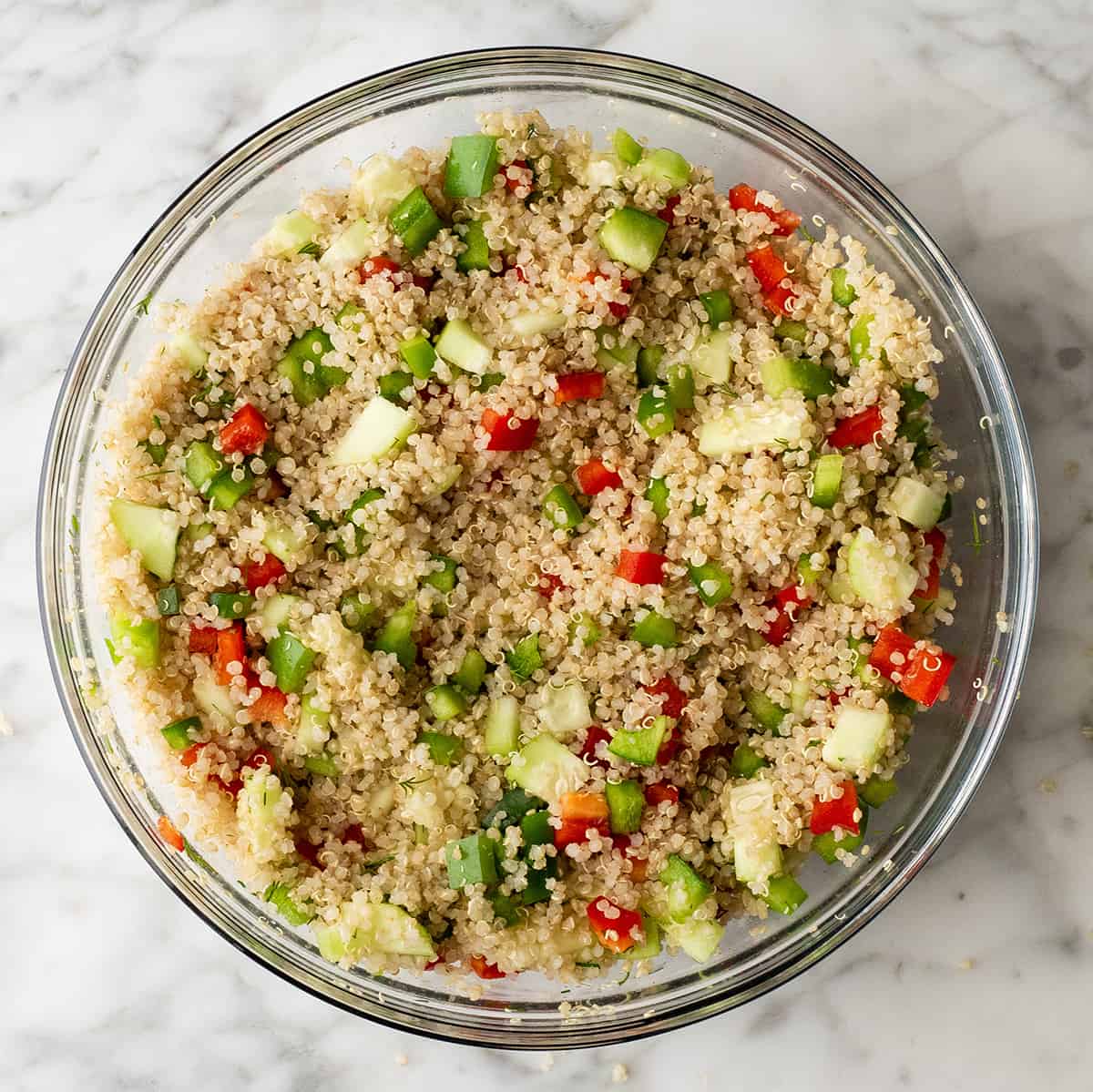 making quinoa salad in a glass bowl 