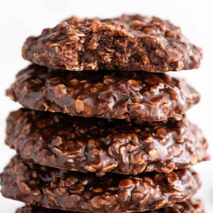 up close photo of a no bake cookie with a bite taken out, stacked on three other no bake cookies