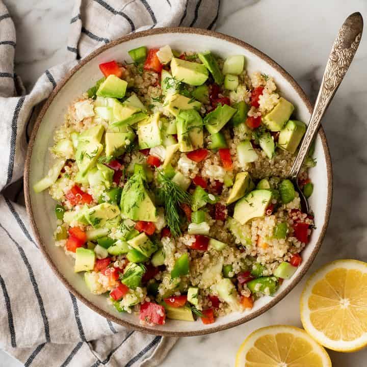 overhead photo of a bowl of quinoa salad with a spoon in it