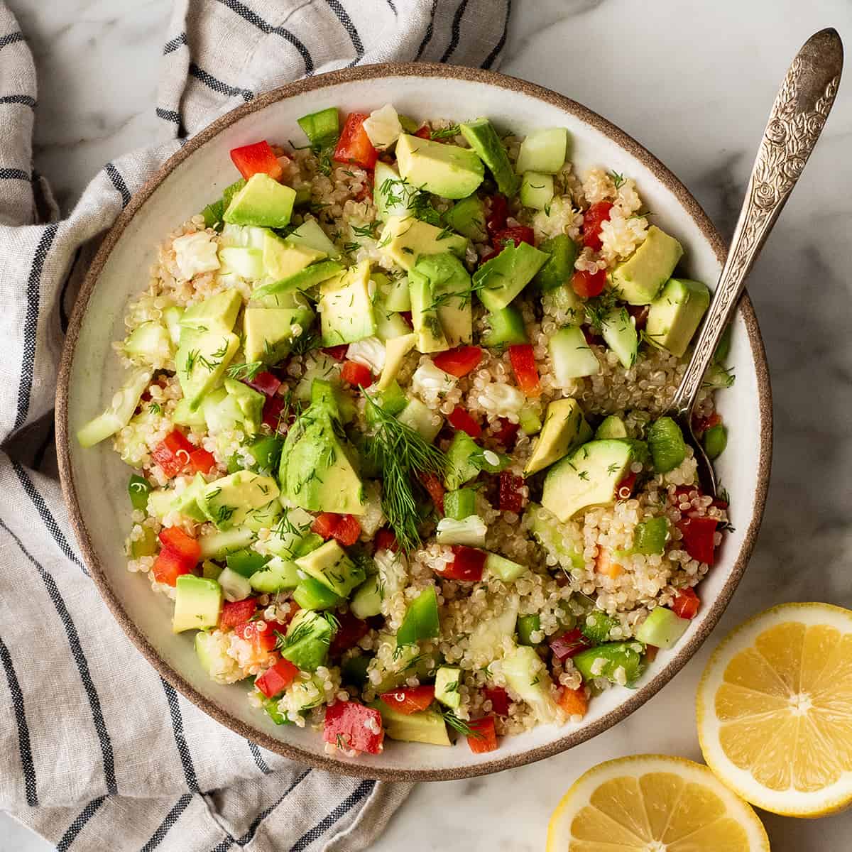 overhead photo of a bowl of quinoa salad with a spoon in it