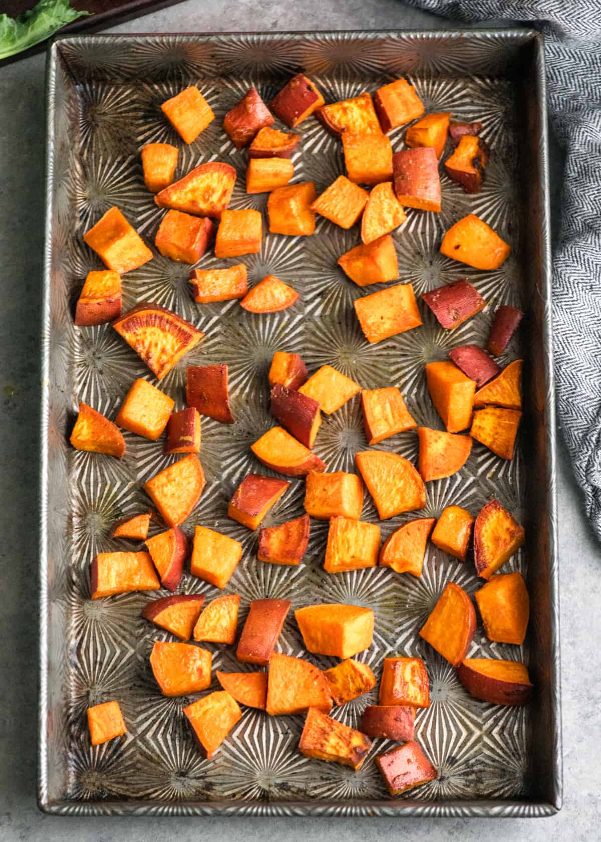 Overhead view of slightly roasted sweet potatoes in the baking pan. 