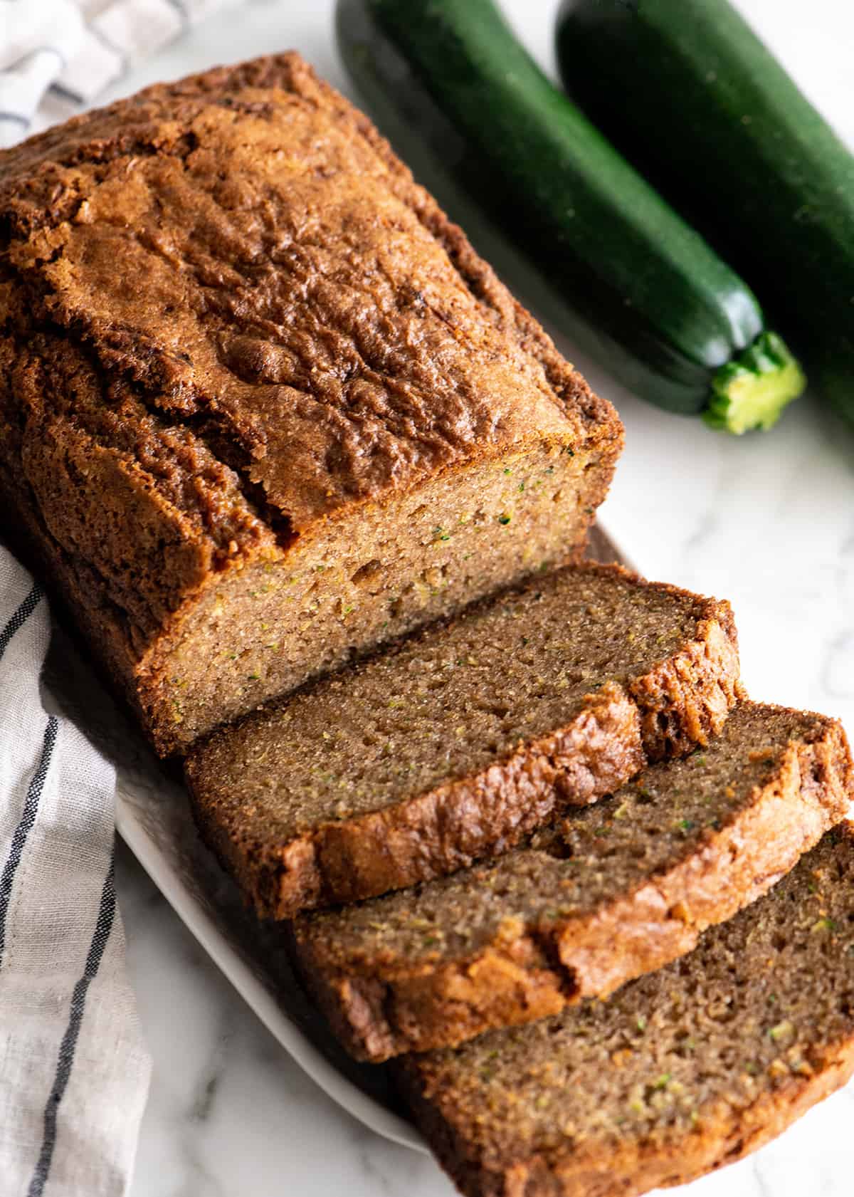 front view of a loaf of zucchini bread with 3 slices cut