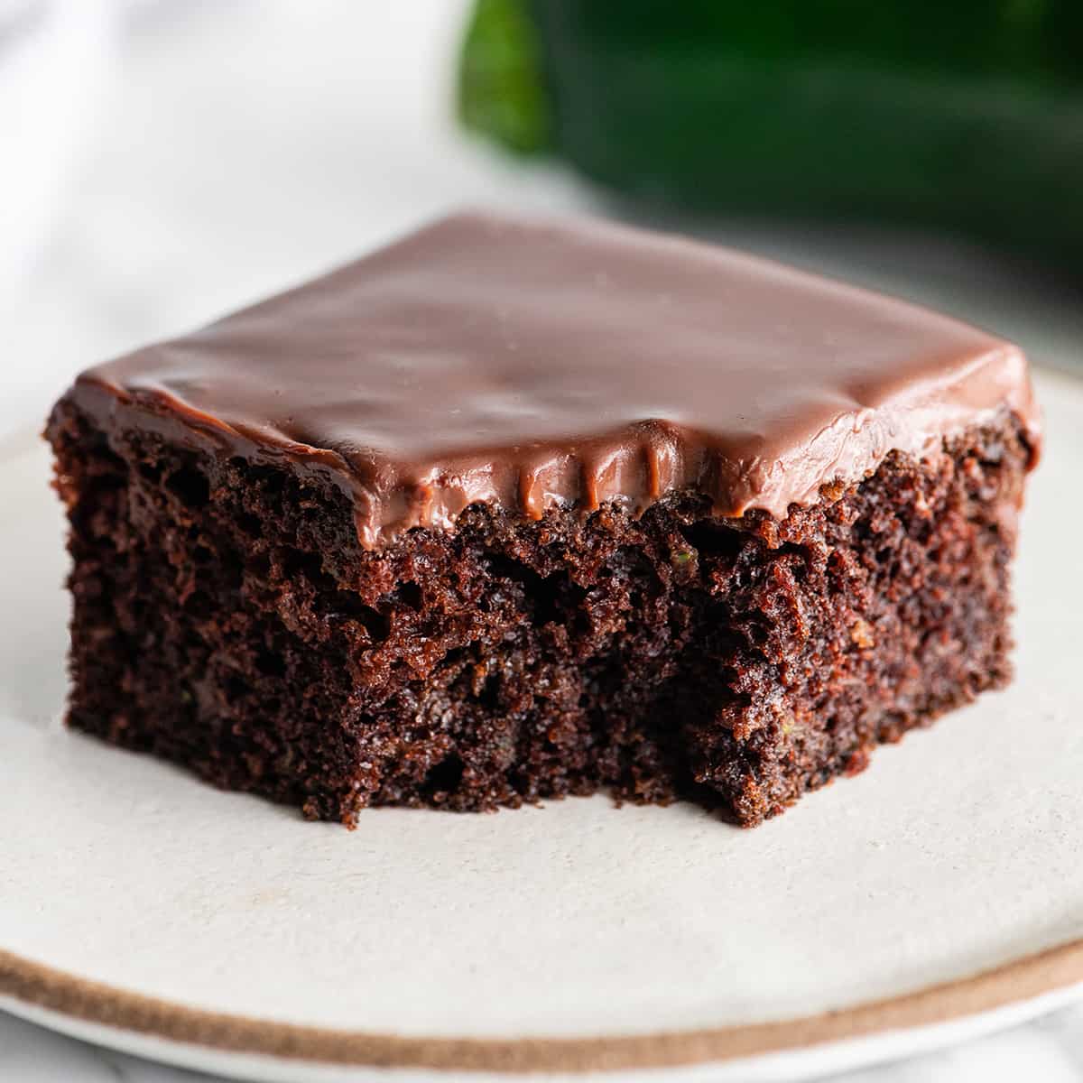 front view of a piece of chocolate zucchini cake with chocolate ganache