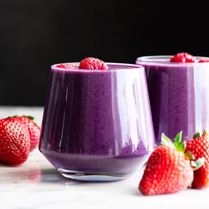 front view of two berry smoothies in glass cups