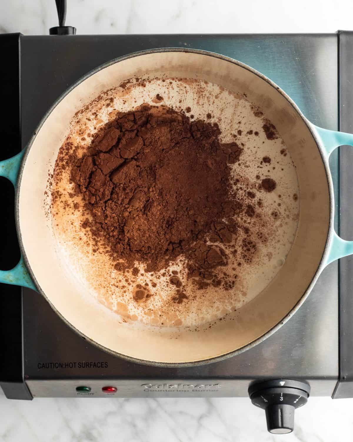 how to make chocolate ice cream - heavy cream and cocoa powder in a blue dutch oven before mixing