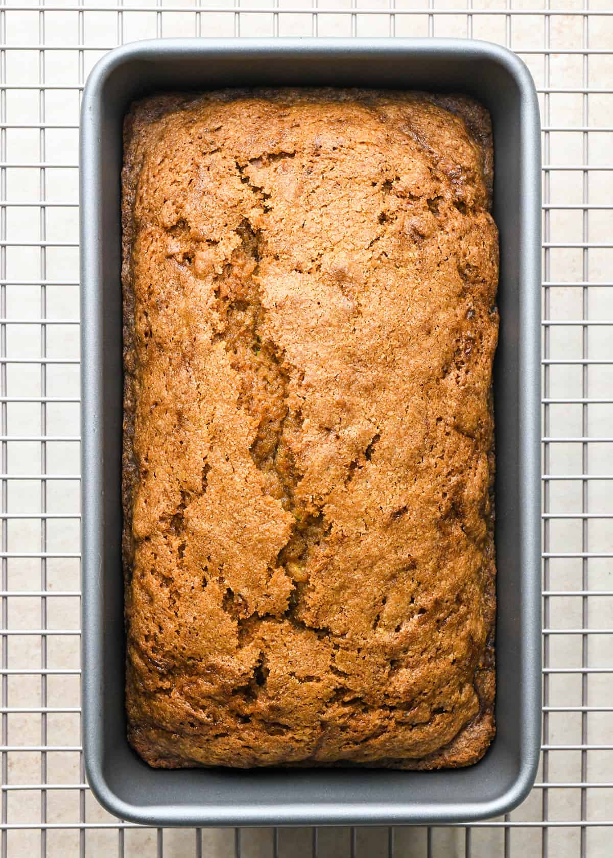 baked Zucchini Bread in a loaf pan on a wire cooling rack