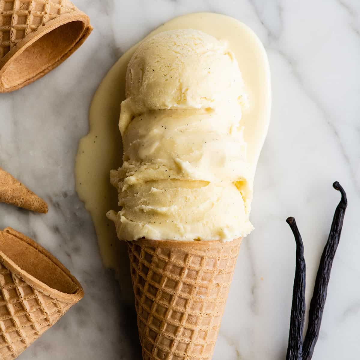 3 scoops of vanilla ice cream on a sugar cone