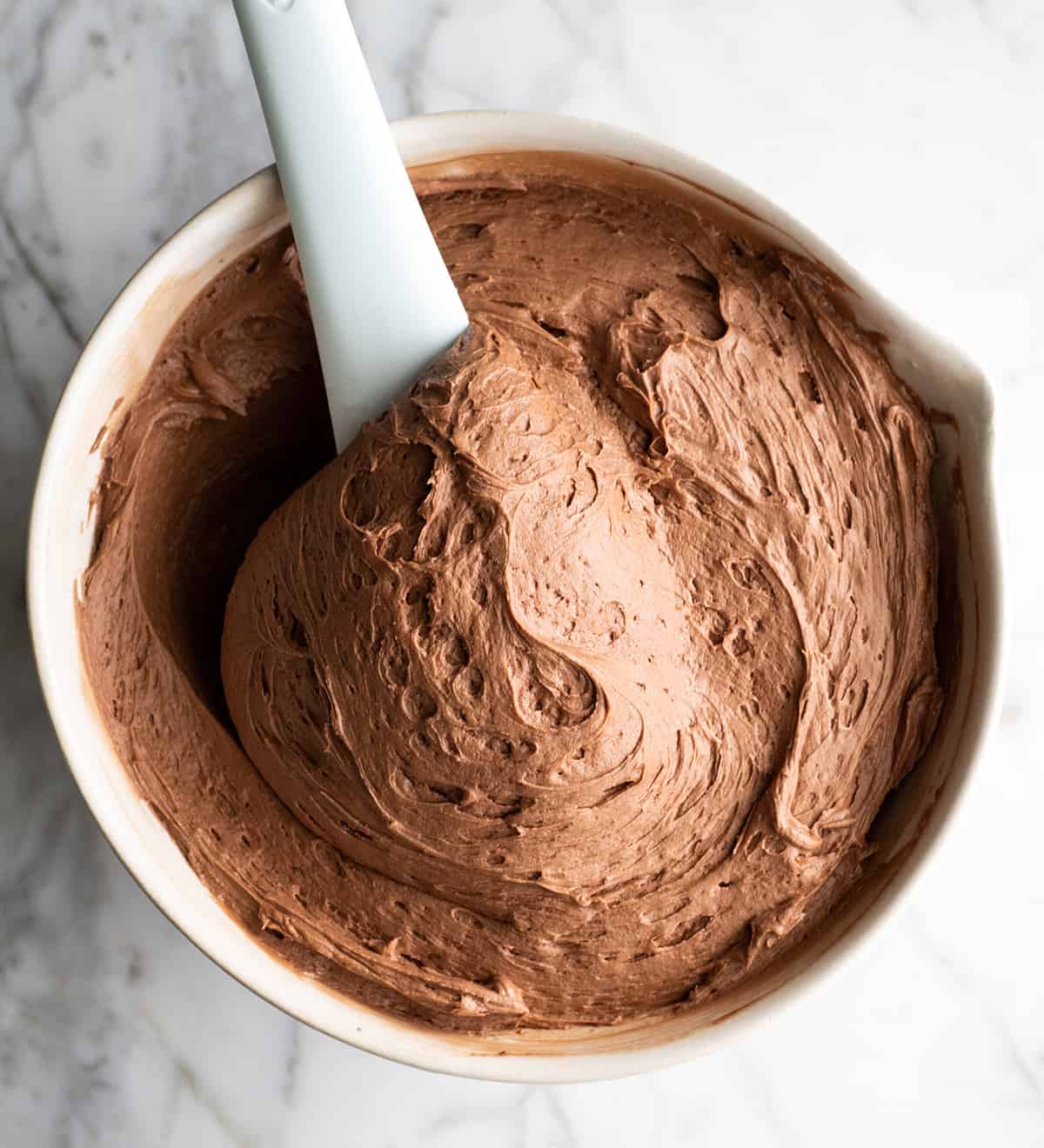 overhead photo of a bowl of chocolate buttercream frosting