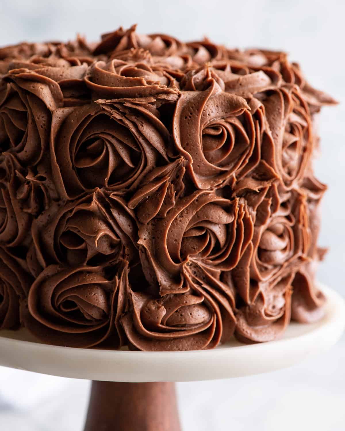 front view of a cake decorated with chocolate buttercream frosting rosettes