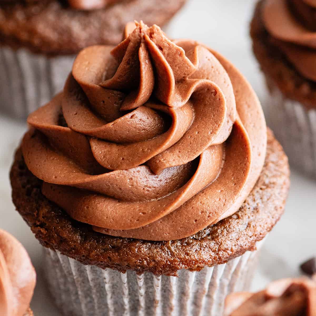 chocolate buttercream frosting piped on top of a chocolate cupcake