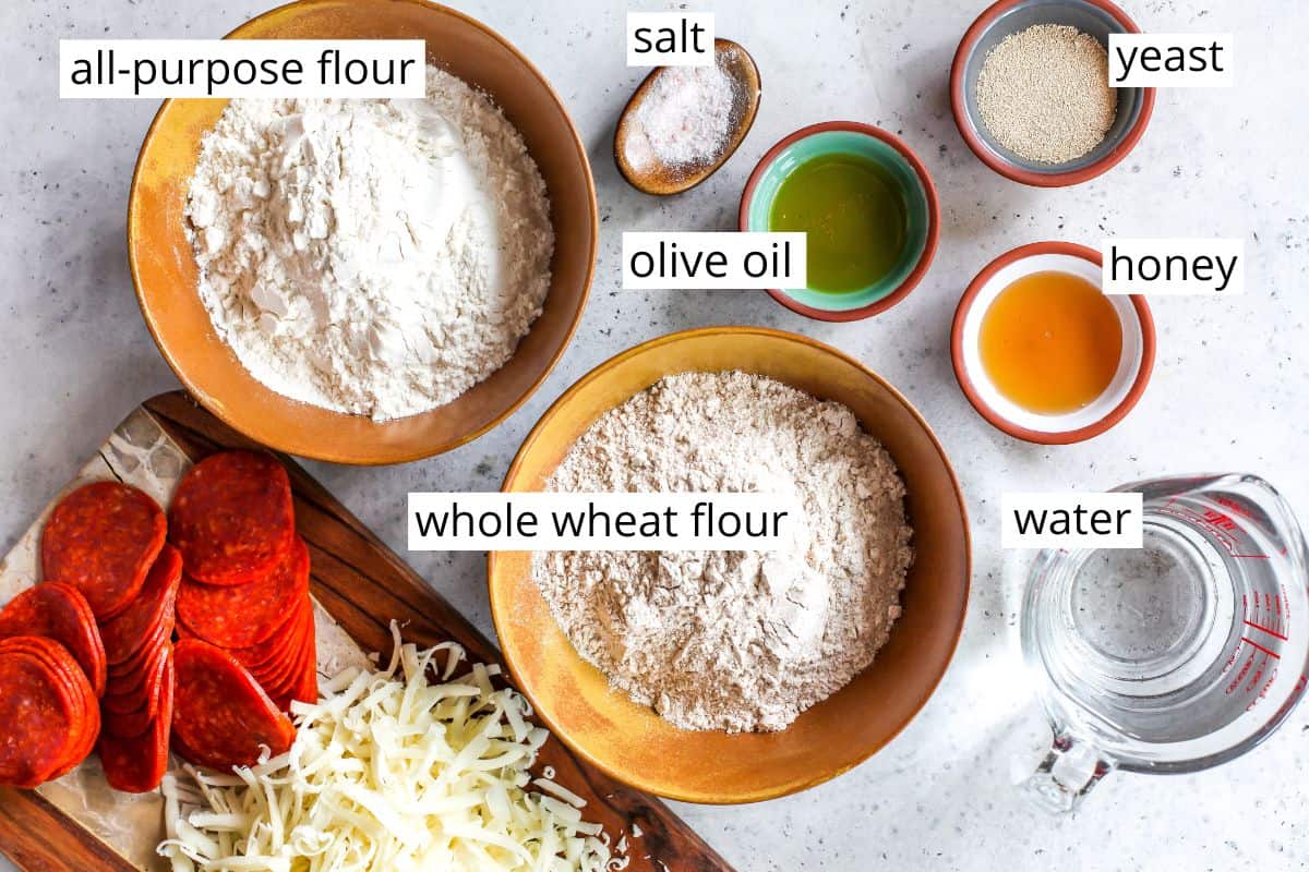 overhead view of the labeled ingredients in this whole wheat pizza dough recipe
