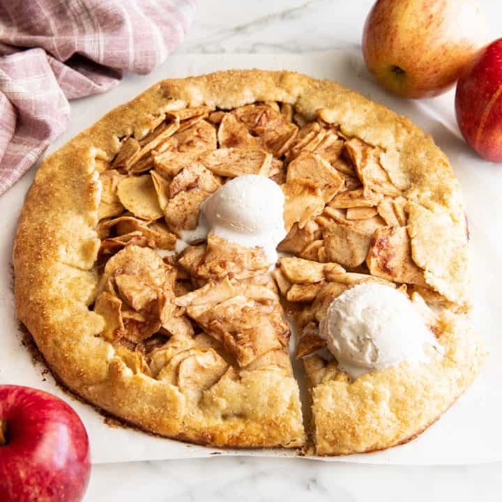Apple galette with a piece cut out and vanilla ice cream
