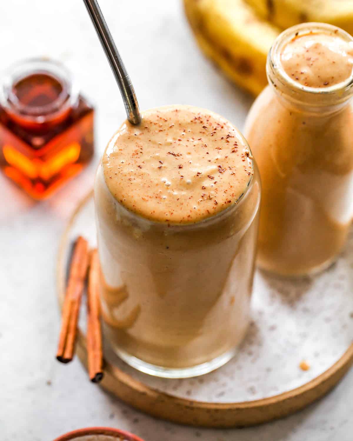 two glasses of pumpkin smoothie with a ground cinnamon on top