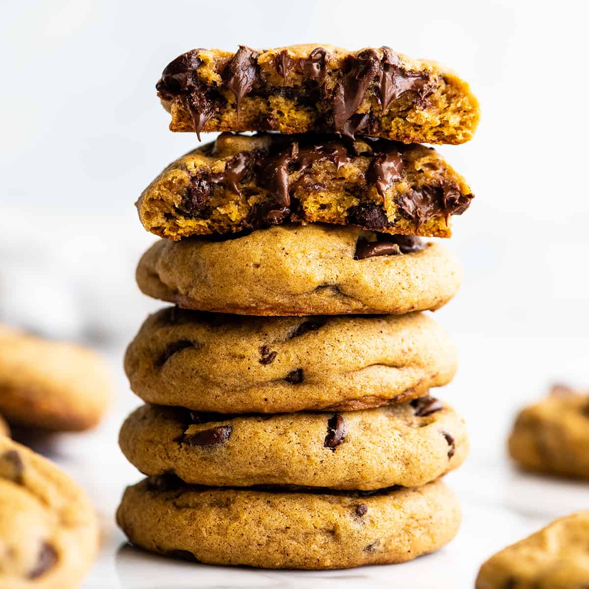 front view of a stack of 5 Pumpkin Chocolate Chip Cookies, the top one cut in half 