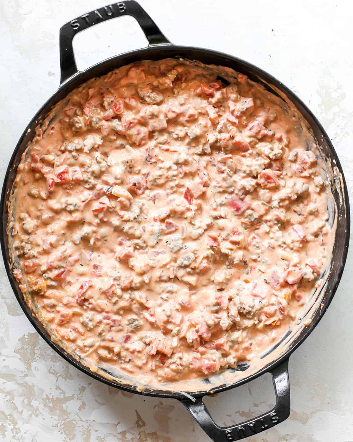 final cream cheese sausage dip in a black cast iron skillet.