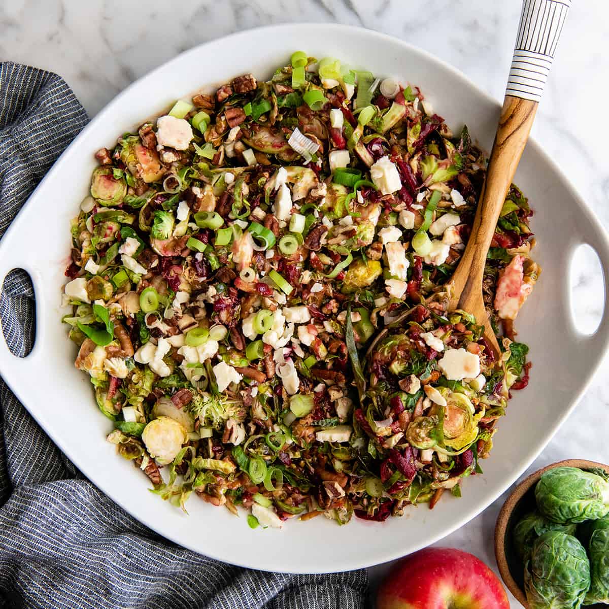 overhead photo of a Brussel Sprouts Salad in a serving bowl with a spoon
