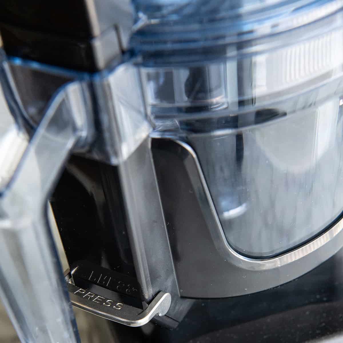 up close photo of the work bowl release button the Vitamix food processor attachment