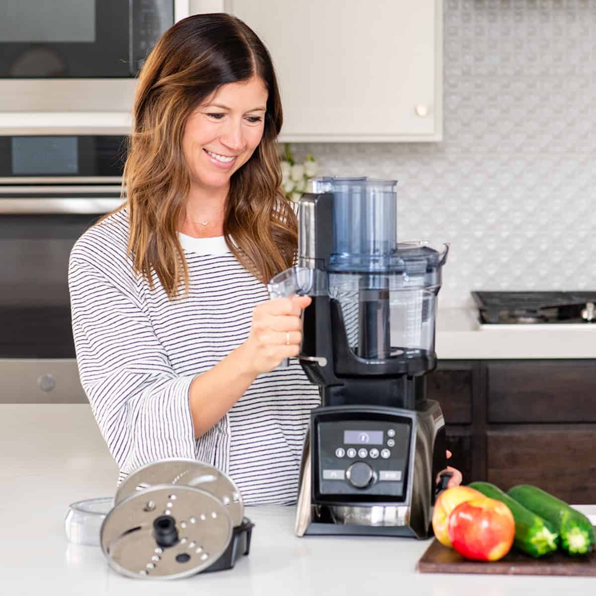 Woman holding vitamix food processor attachment 