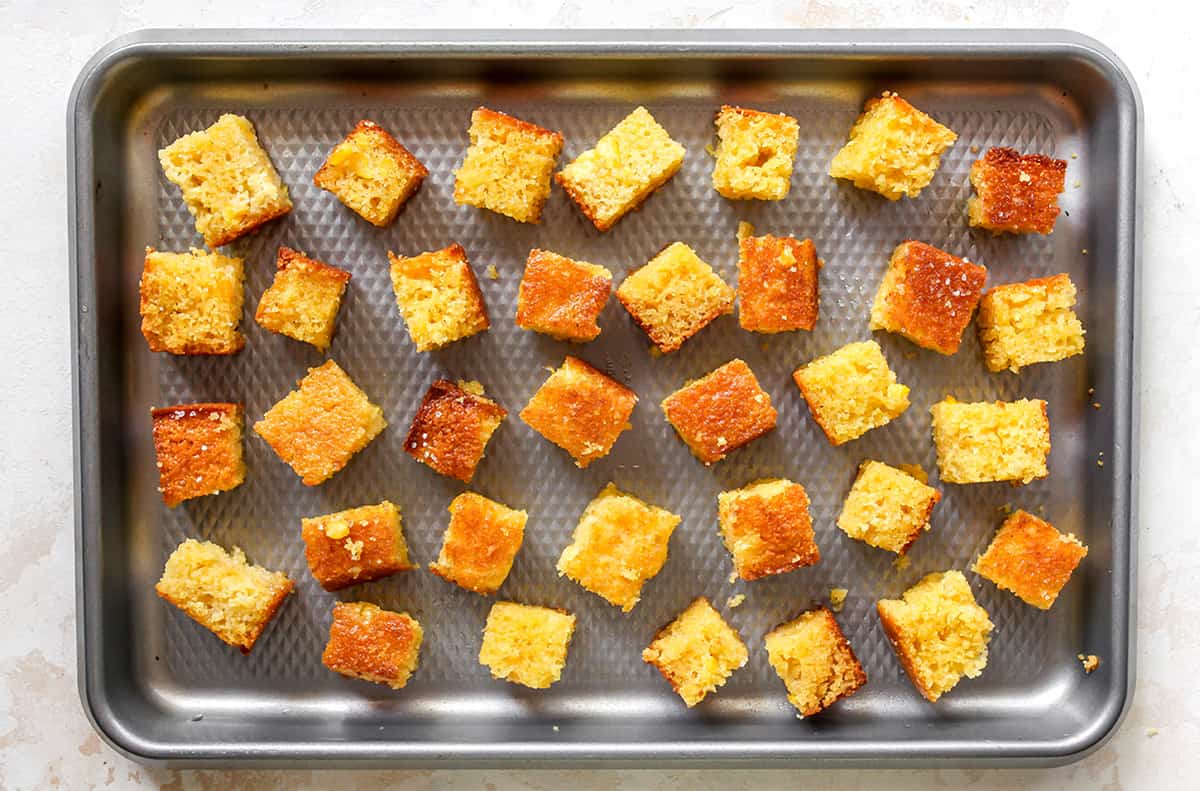 overhead photo showing Cornbread Croutons on a baking sheet before being baked