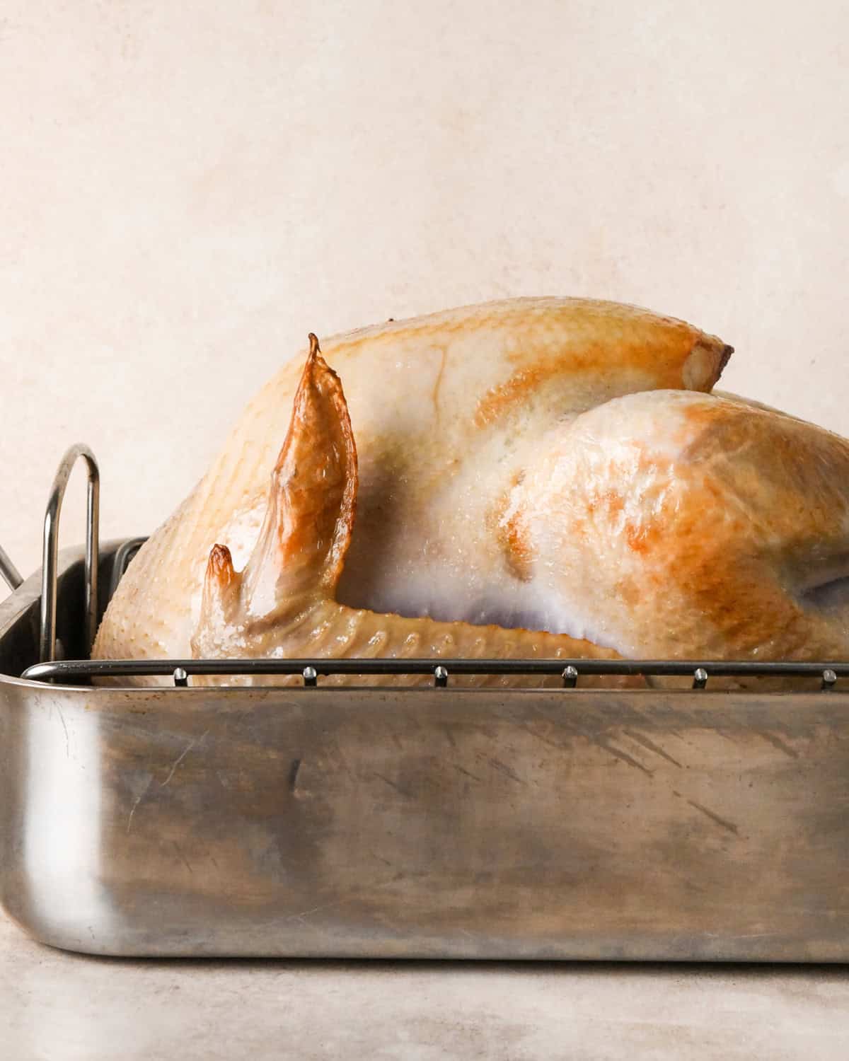 oven roasted turkey in a roasting pan after roasting for 30 minutes in the oven