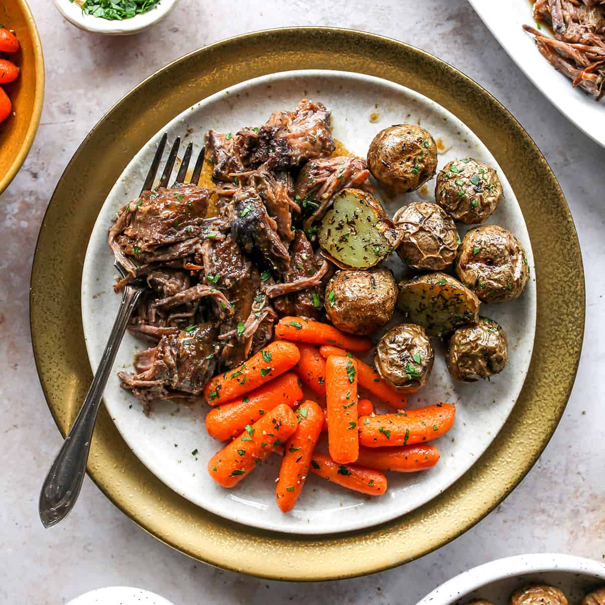 Slow Cooker Pot Roast on a plate with carrots and potatoes