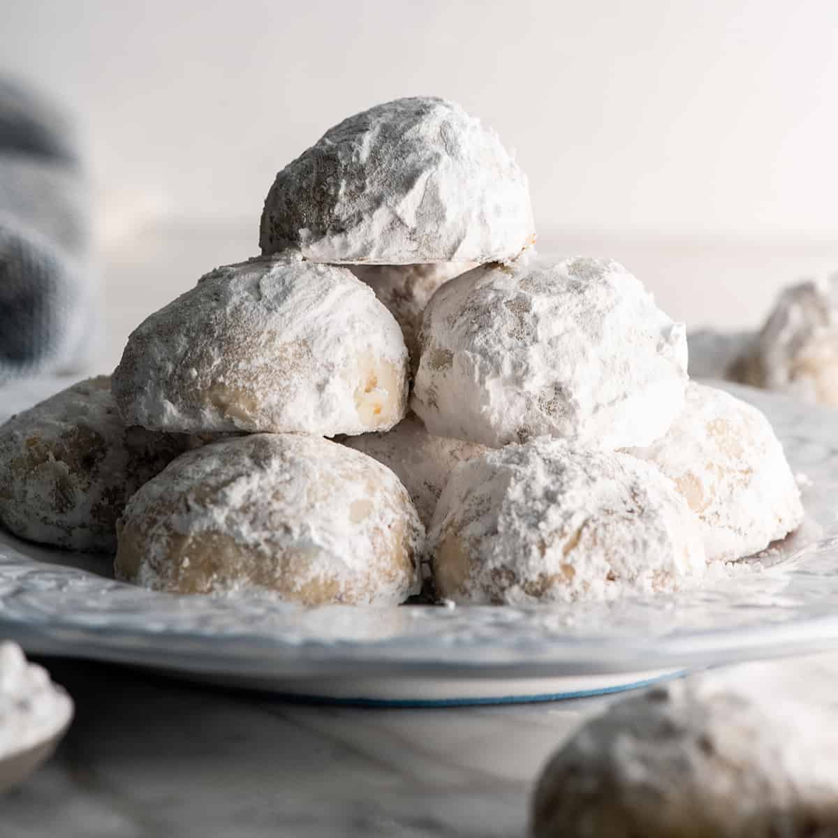 front view of a stack of snowball cookies on a plate
