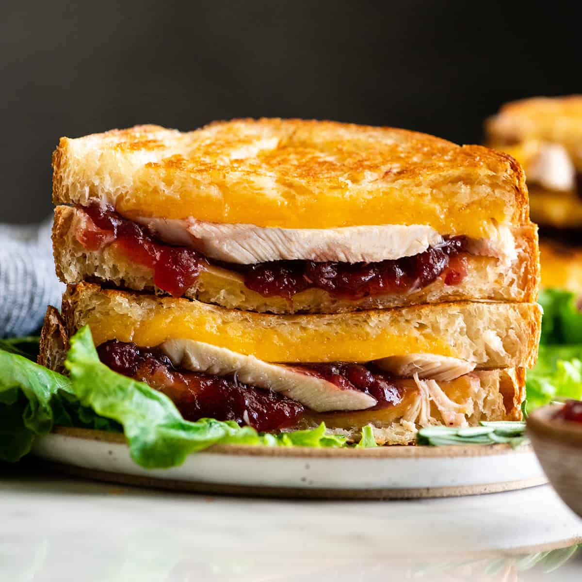 front view of two halves of a turkey cranberry sandwich stacked on each other