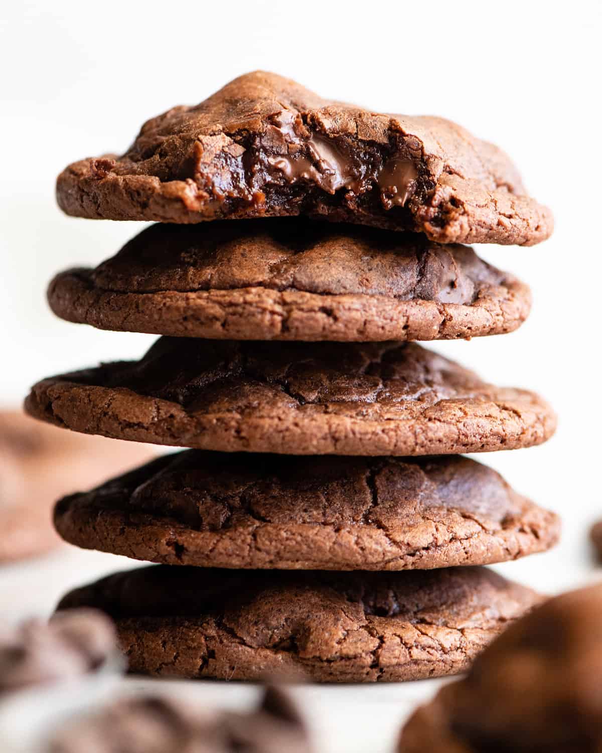 a stack of 5 brownie cookies, the top one has a bite taken out of it