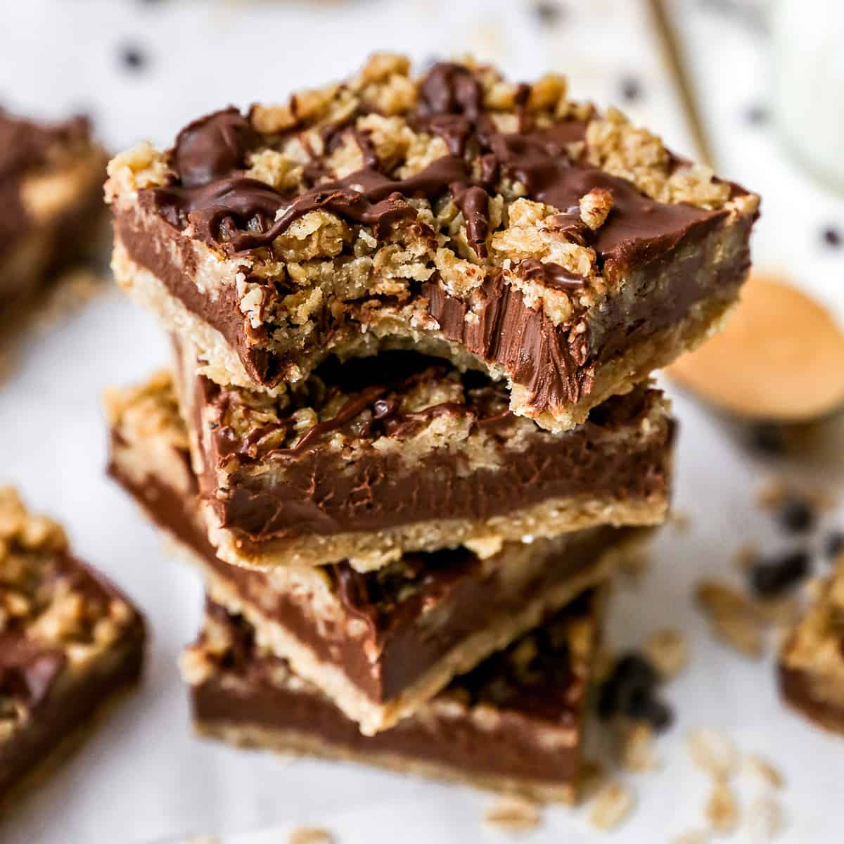 stack of 4 chocolate peanut butter oatmeal bars, the top one has a bite taken out of it