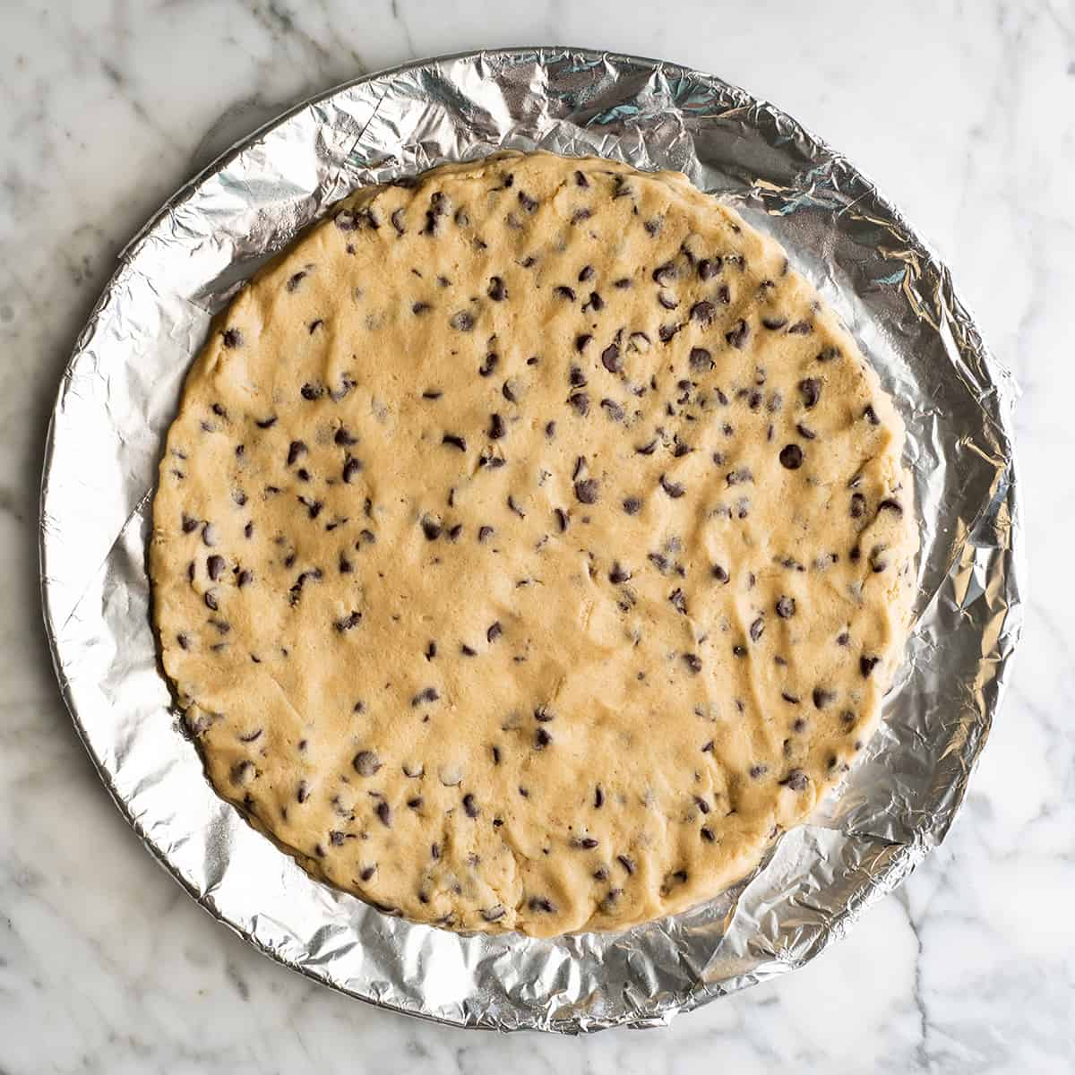 chocolate chip cookie cake on a baking sheet before baking