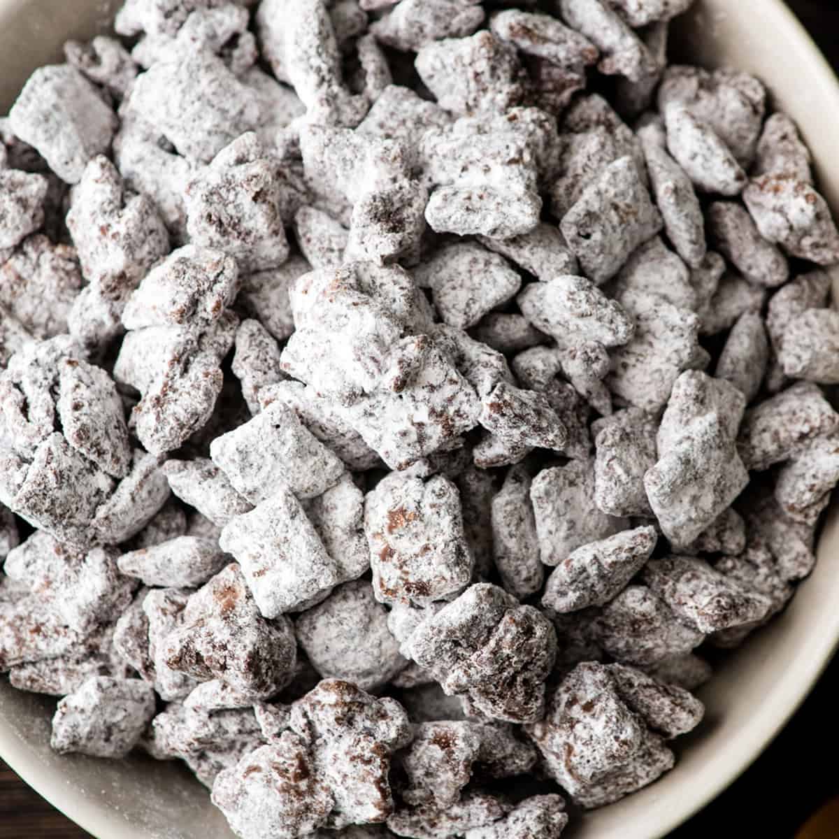 making reindeer food - puppy chow mixture in a ceramic bowl coated in powdered sugar