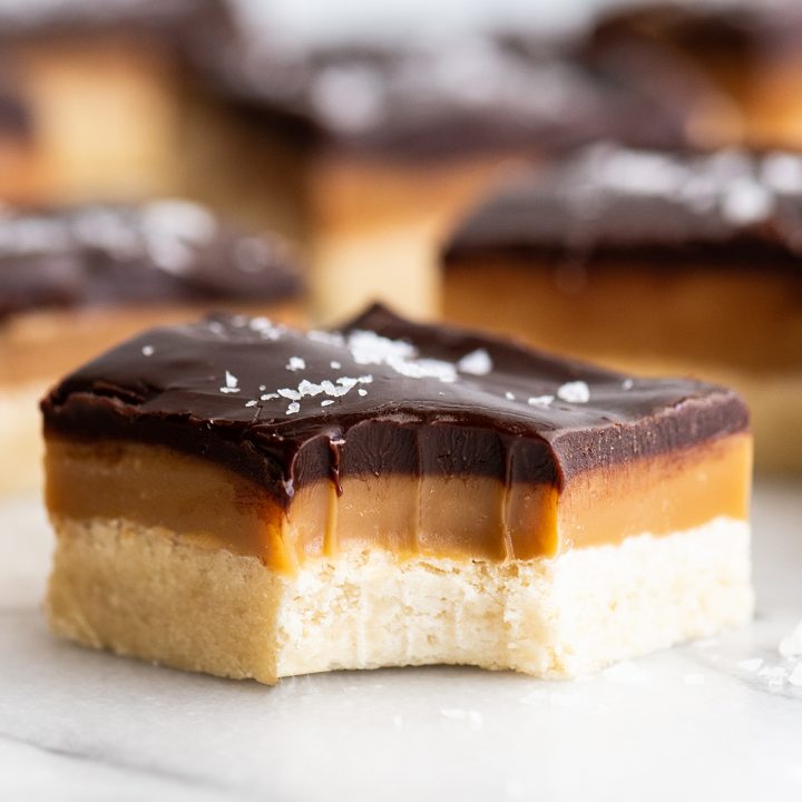 front view of a millionaire shortbread bar with a bite taken out of it