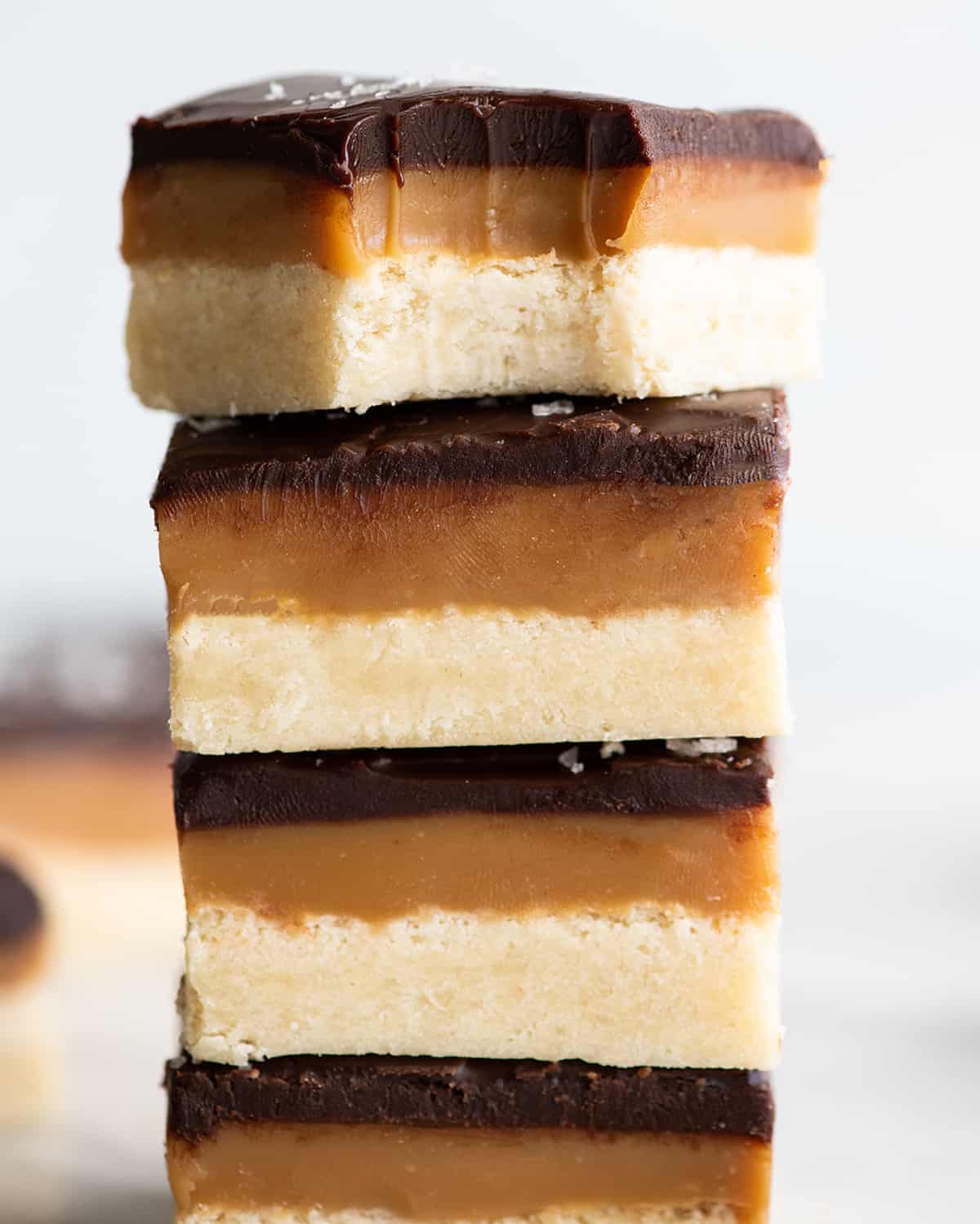 stack of 4 millionaire shortbread bars, the top has a bite taken out of it