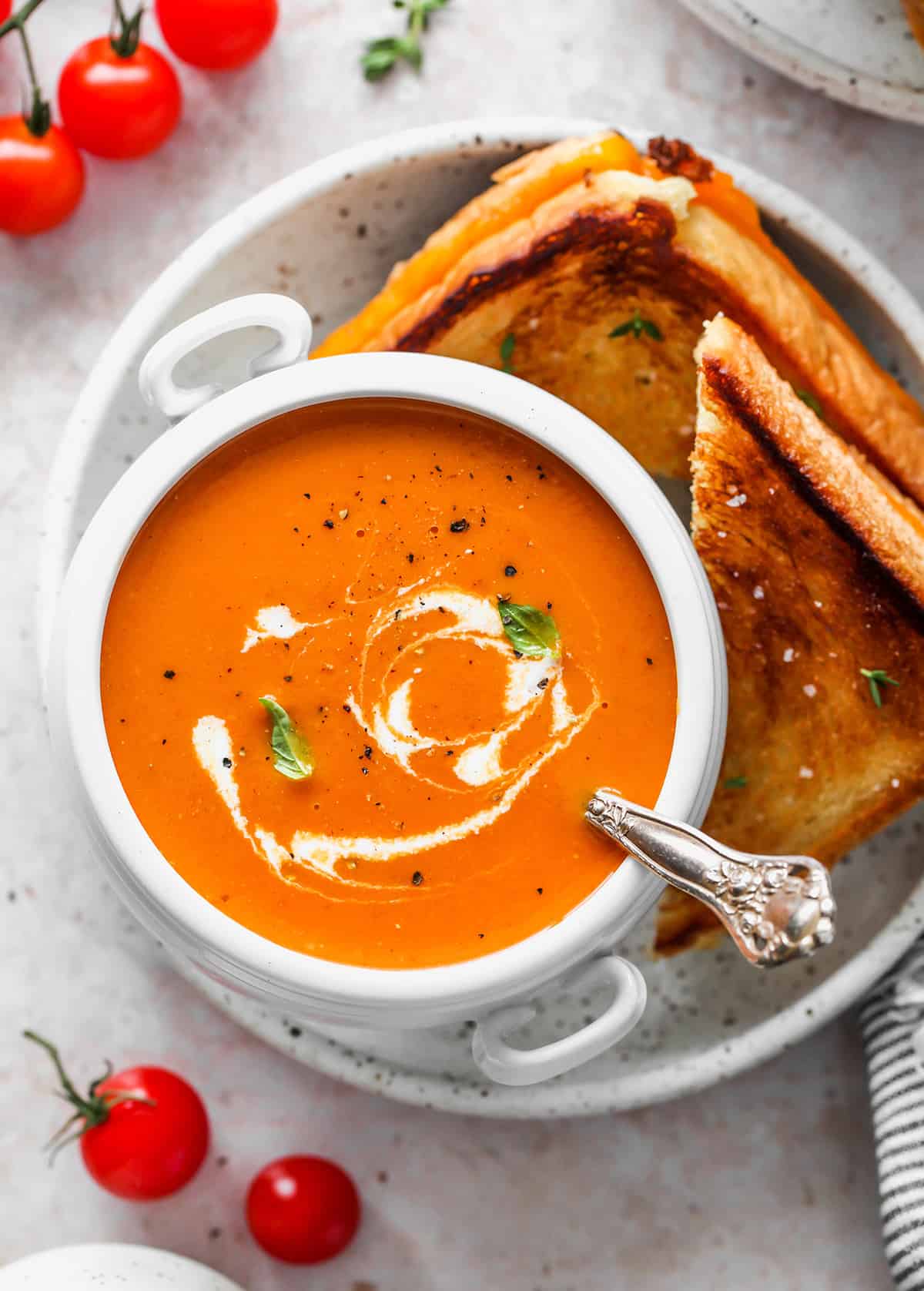 a bowl of Homemade Tomato Soup with grilled cheese on the side