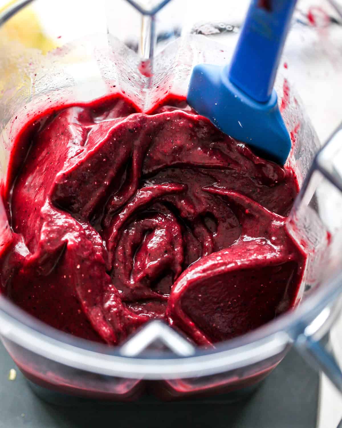 How to Make an Acai Bowl - scraping ingredients into the blades of a blender that is turned off.