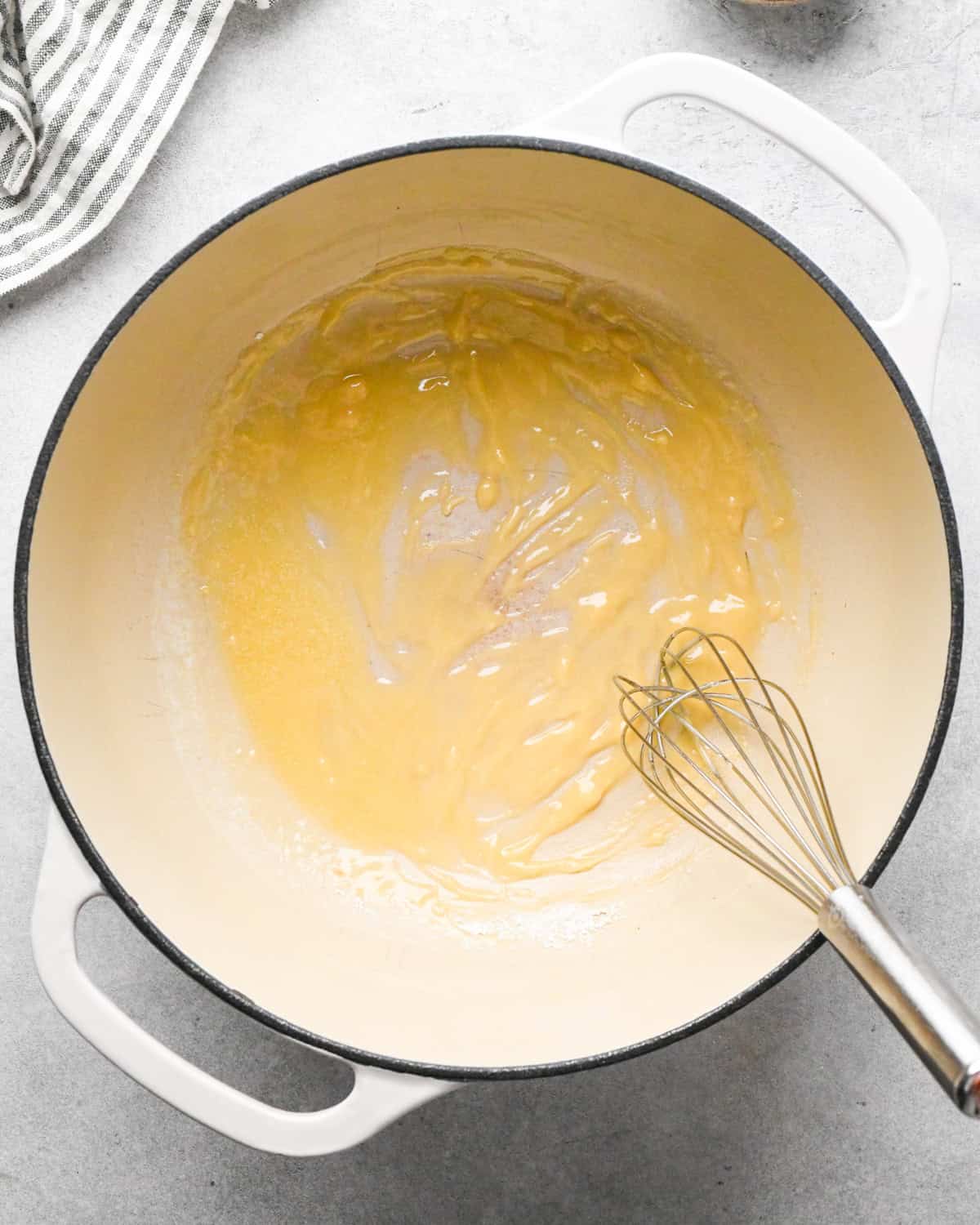 flour whisked into to melted butter in a white pot making homemade tomato soup