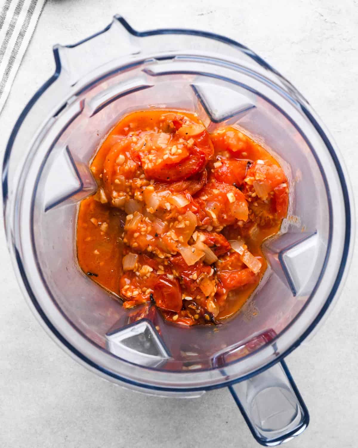 roasted tomato mixture in the container of a vitamix blender before blending making tomato soup