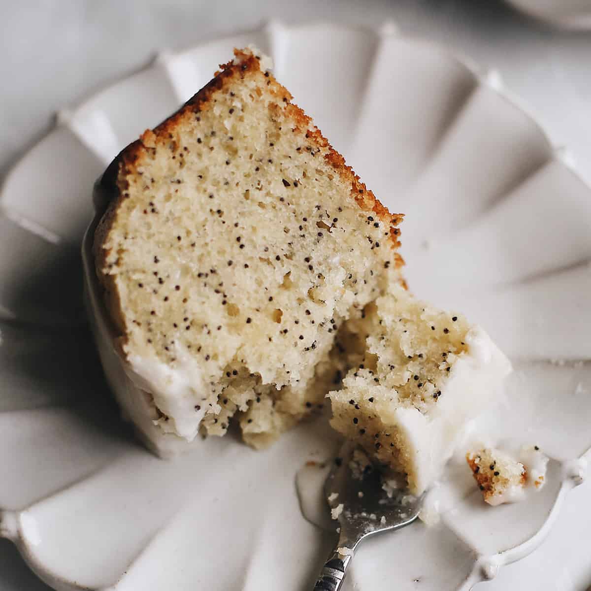 overhead view of a slice of Poppy Seed Cake with a fork taking a bite