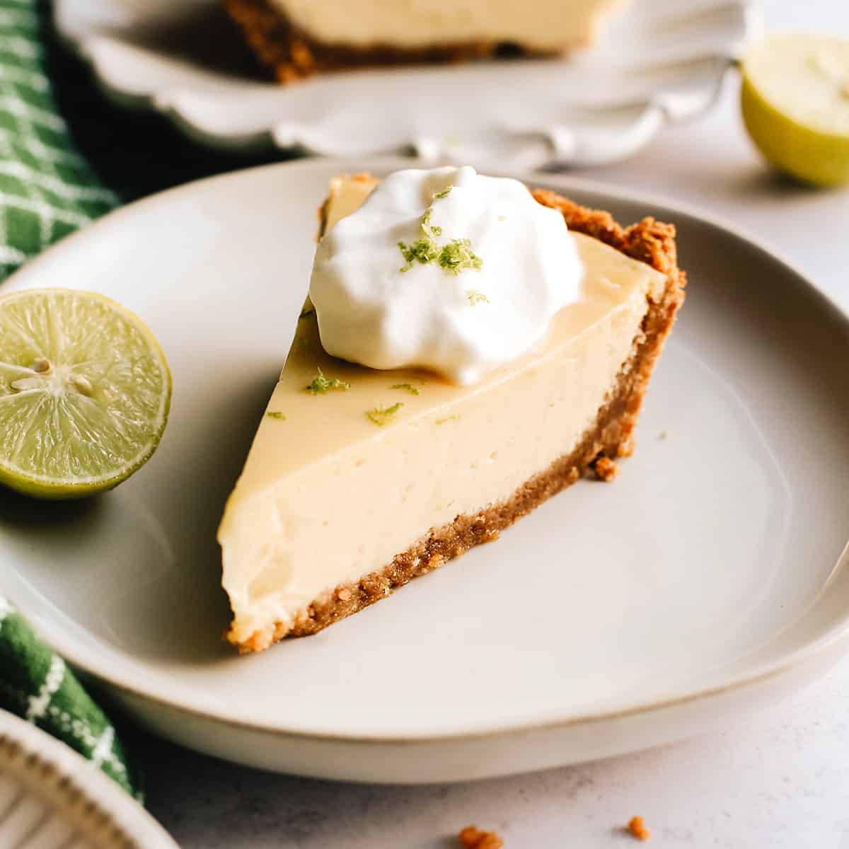a slice of Key Lime Pie on a plate with whipped cream on top