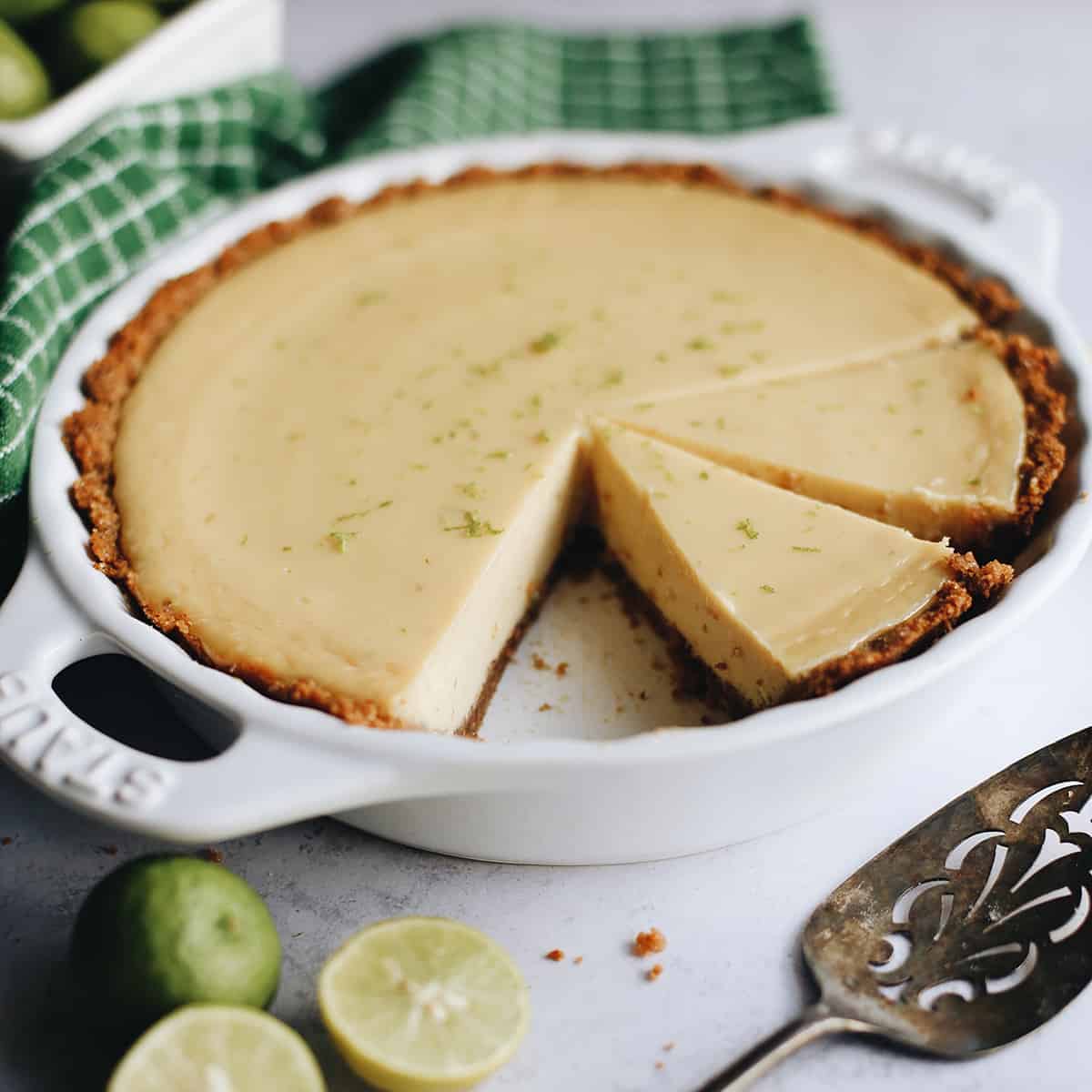 front view of a Key Lime Pie in a pie dish with 2 slices cut out