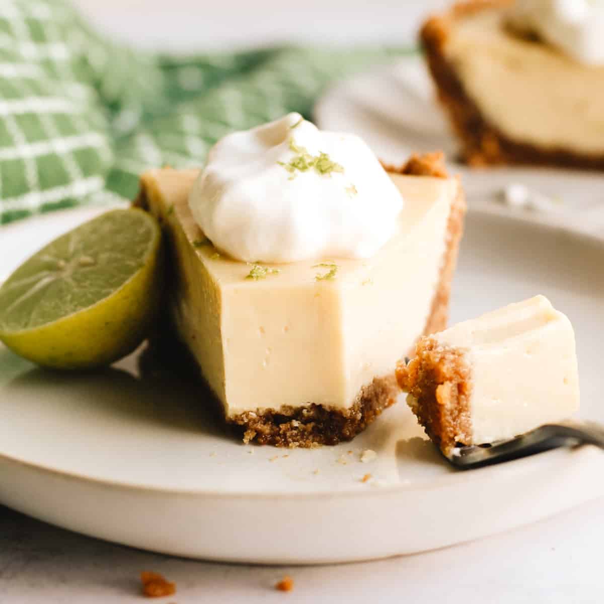 a piece of key lime pie on a plate with a bite taken out of it
