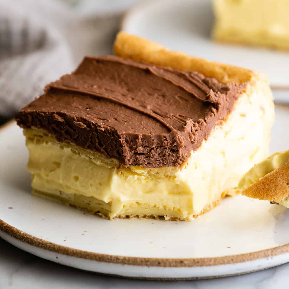 piece of eclair cake on a plate with a bite taken out of it
