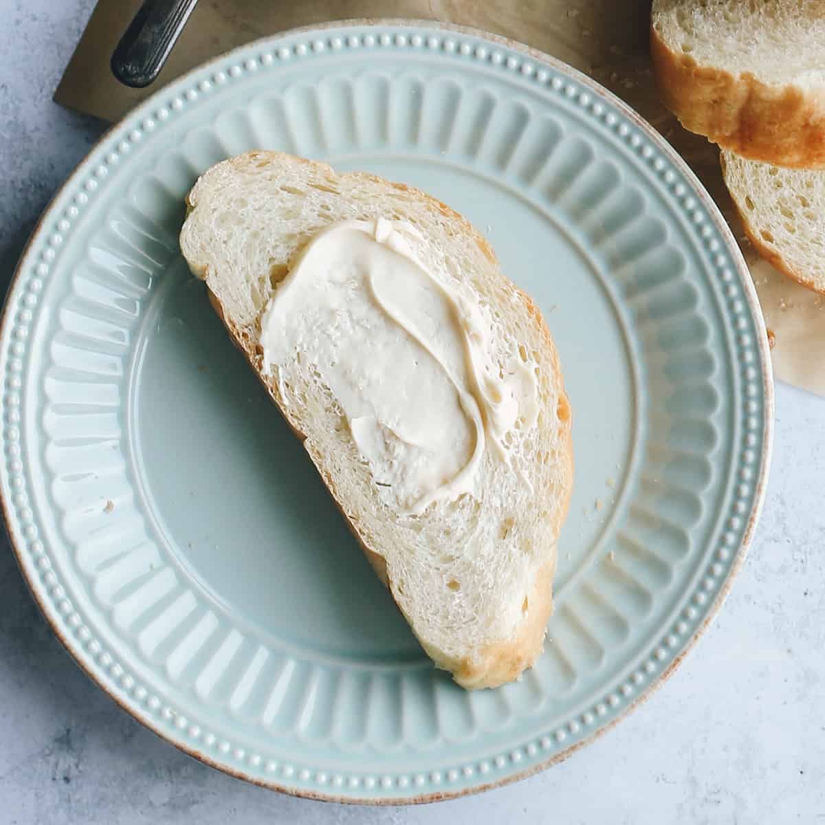 a slice of french bread on a plate with butter