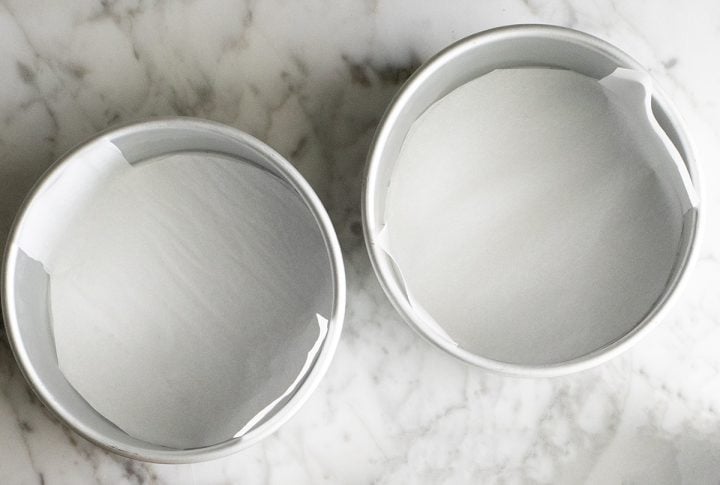 photo of two round cake pans lined with parchment paper
