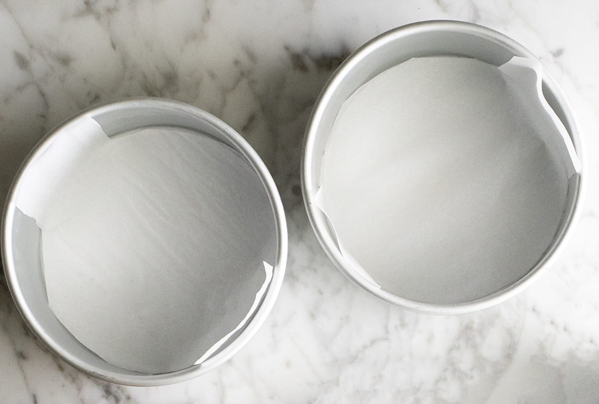 photo of two round cake pans lined with parchment paper