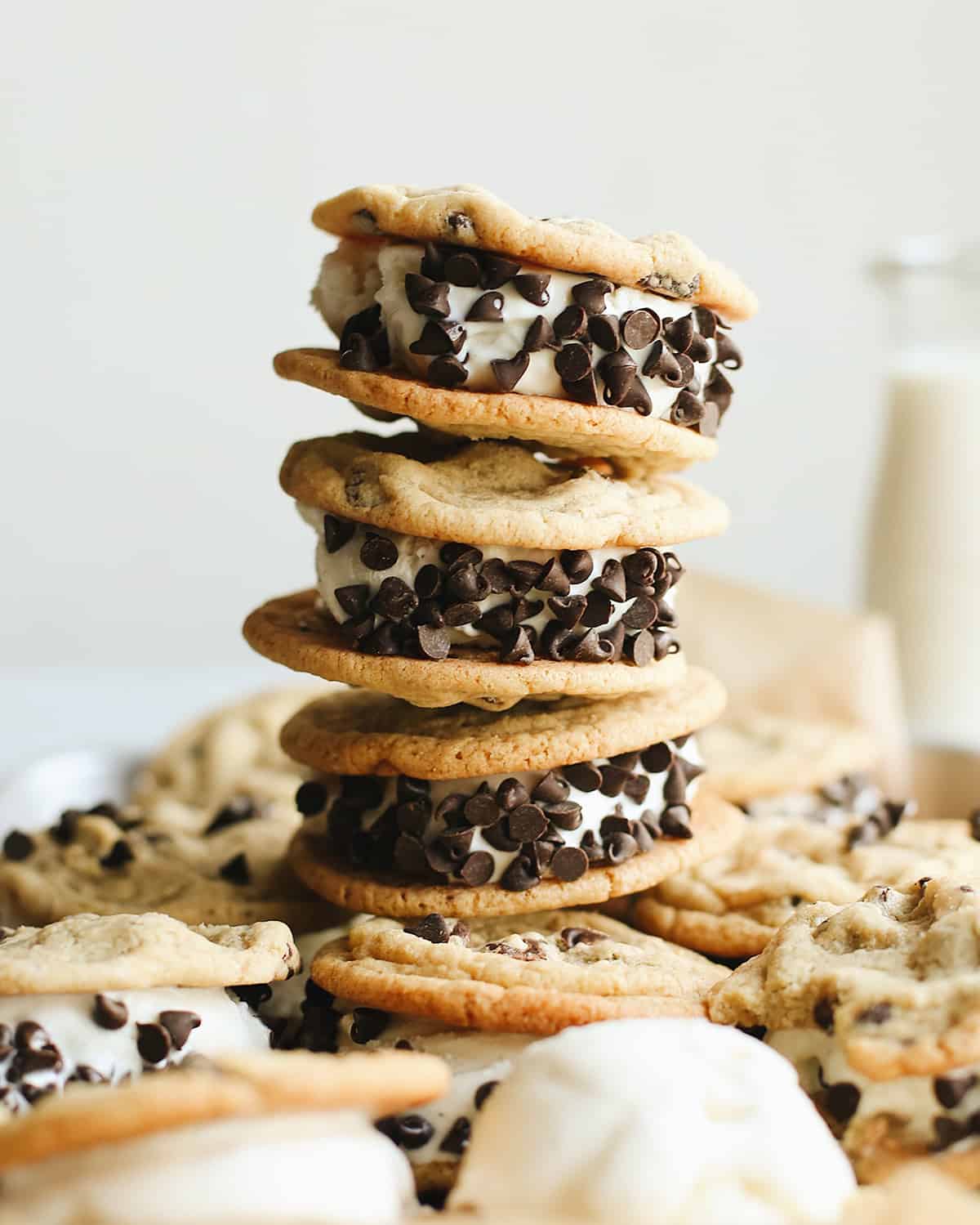 stack of 3 chocolate chip cookie ice cream sandwiches with others around it.