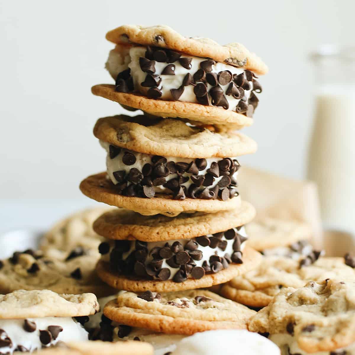 stack of 3 chocolate chip cookie ice cream sandwiches with others around it.