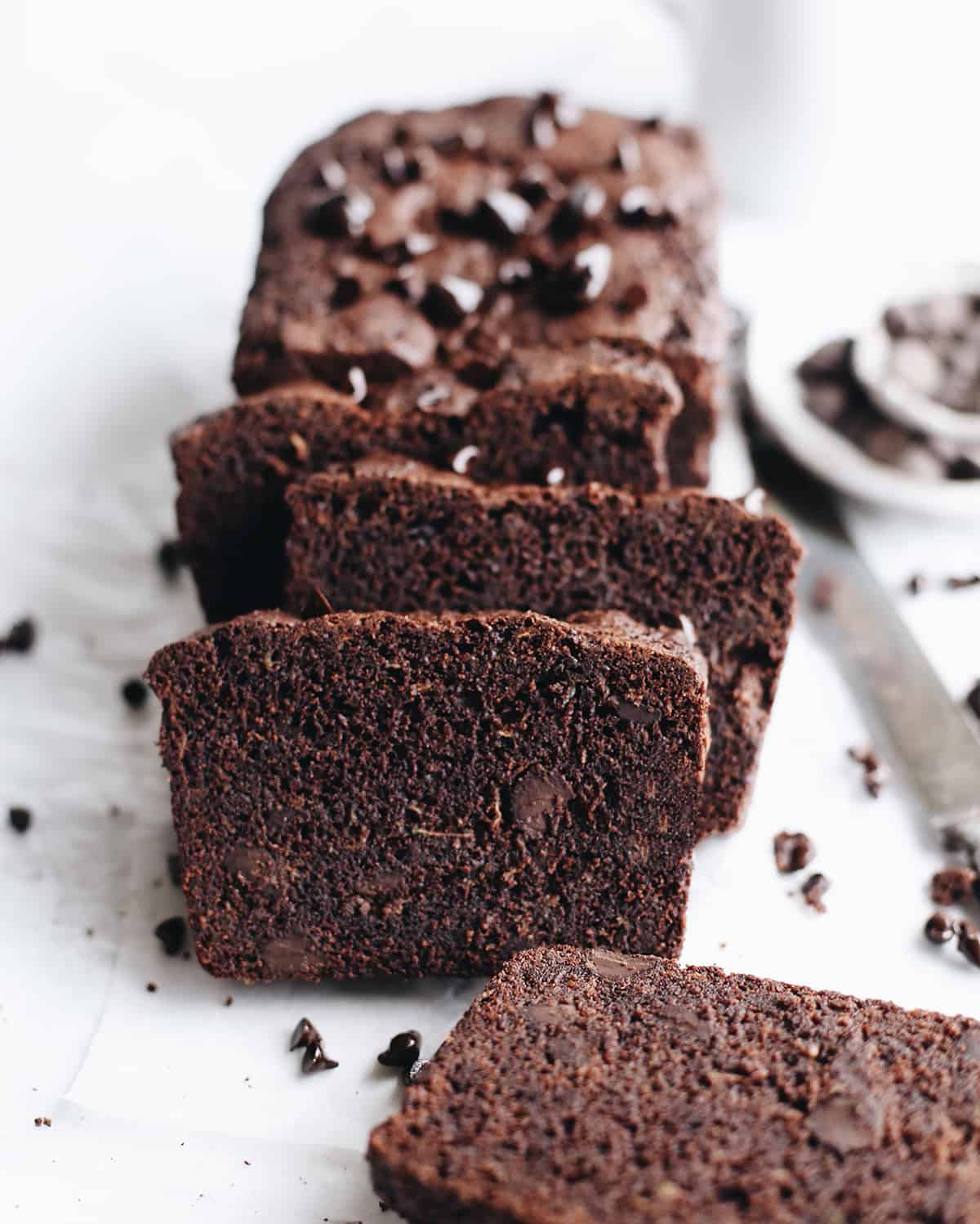 a loaf of Chocolate Zucchini Bread with four slices cut out of it