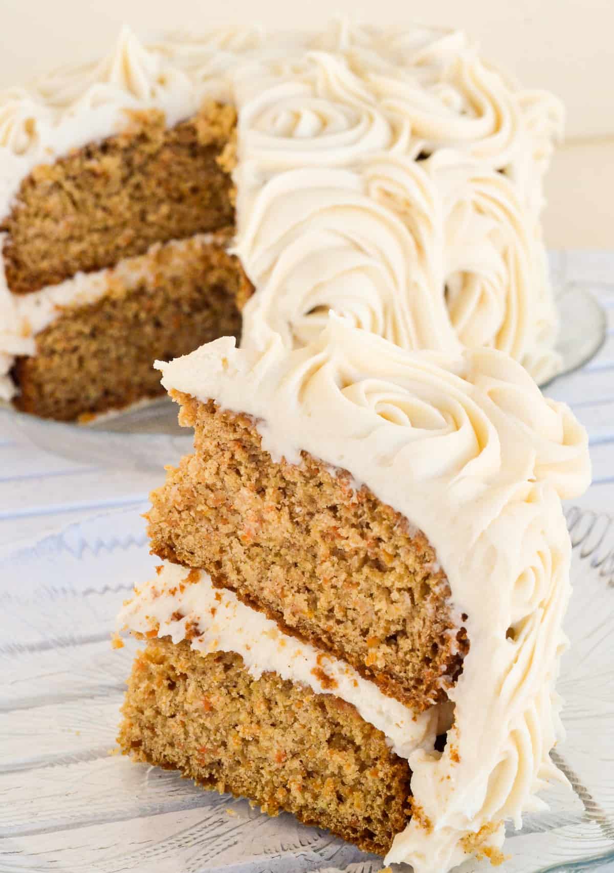 Front view of a slice of cake with the rest of the cake in the background.